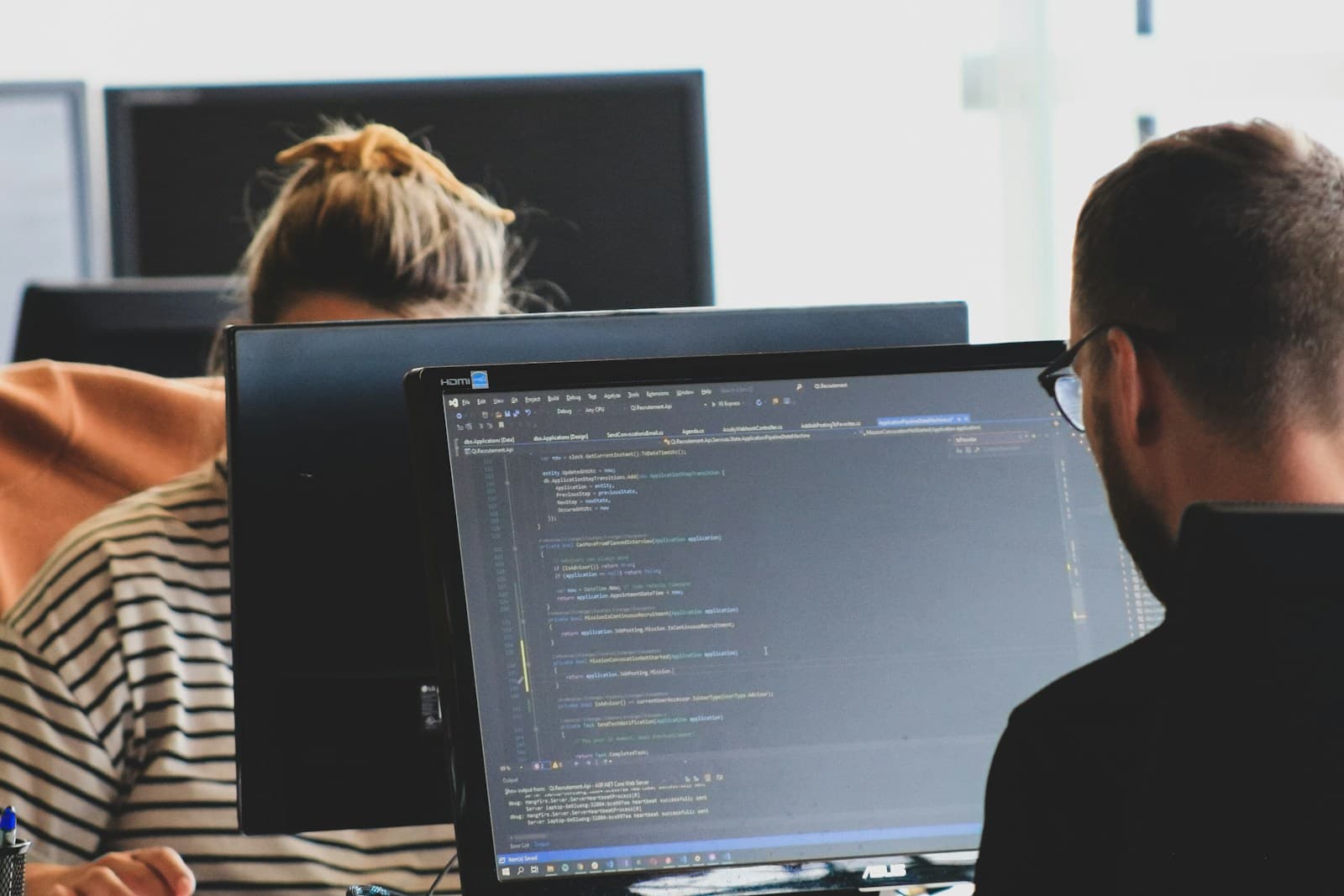 Dues persones programen davant de diverses pantalles