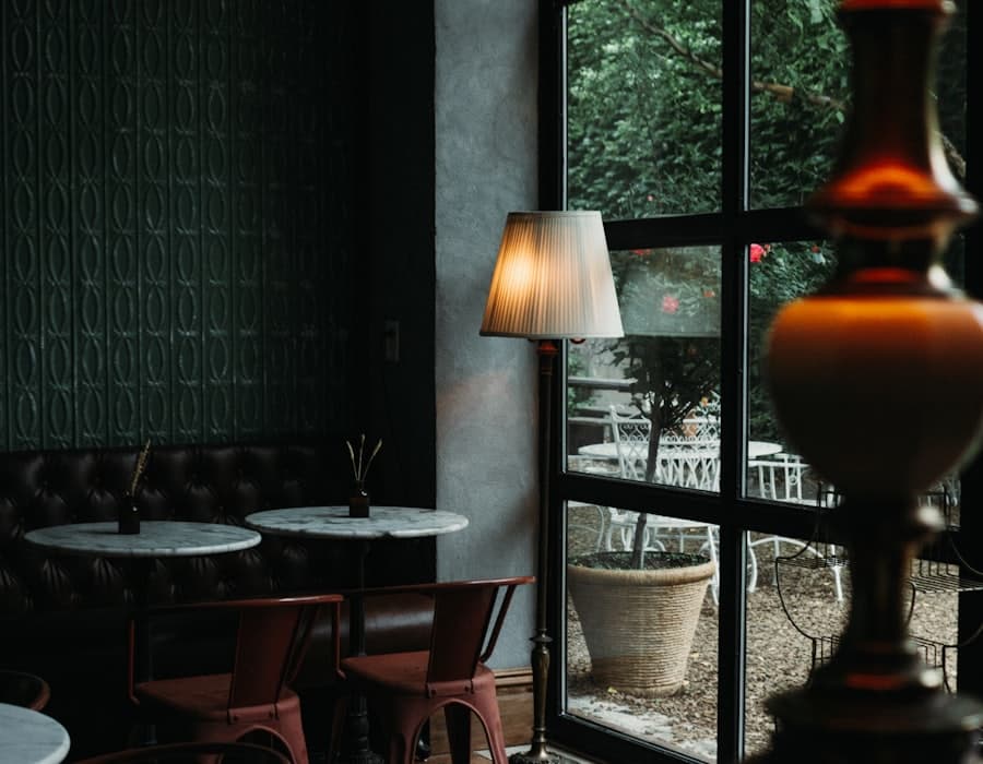 Un bar buit al vespre, amb un llum encès al costat de la finestra
