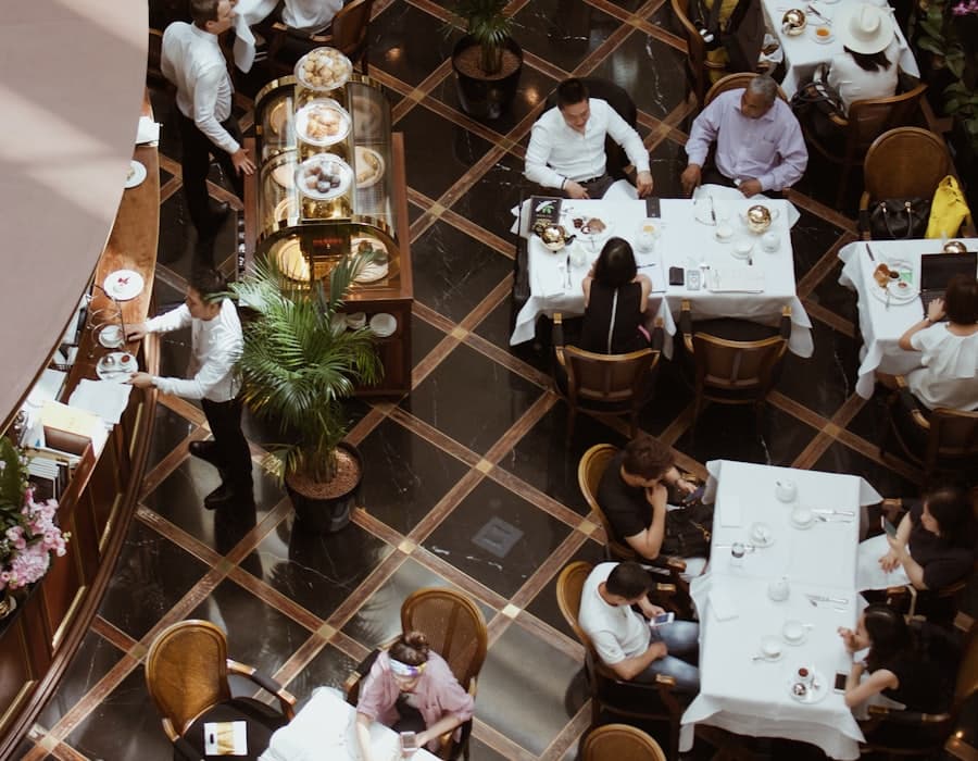 Un restaurant ple vist des de dalt, amb els cambrers servint les taules