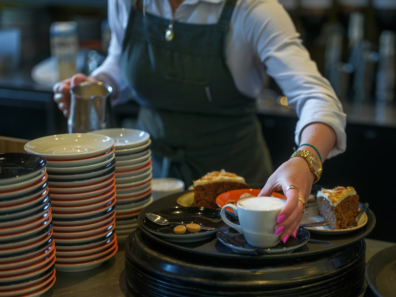 Una cambrera servint cafè i pastís